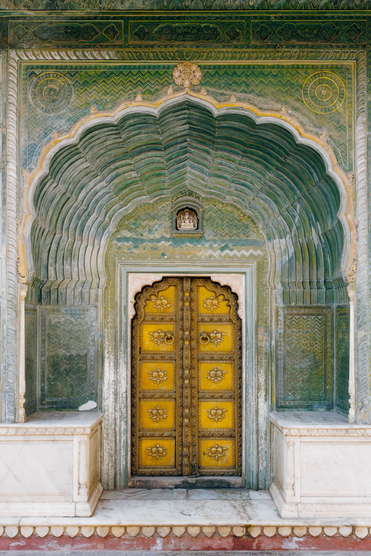 Ornate golden door framed by green archway at City Palace, Jaipur, India